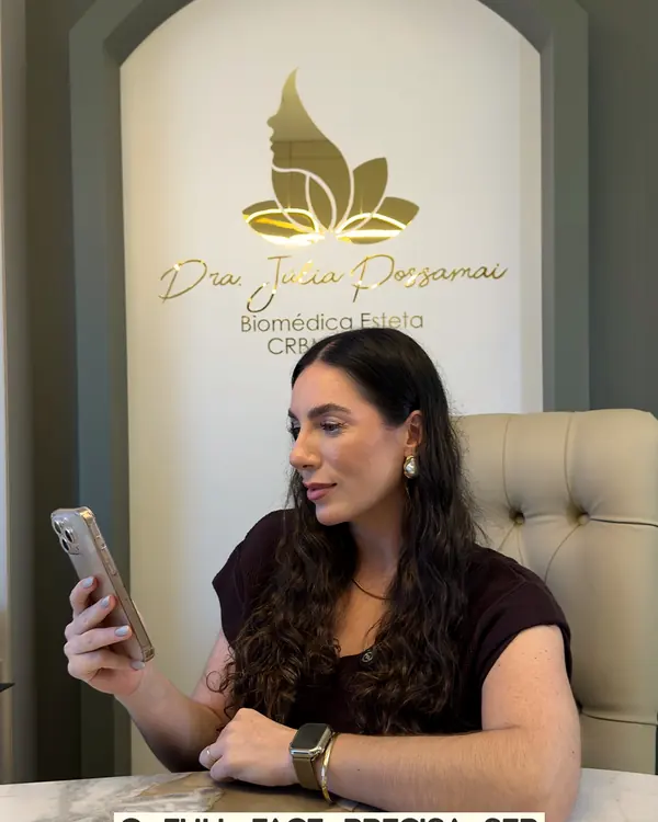 Consultório com a placa dourada do lótus na parede e a profissional à mesa